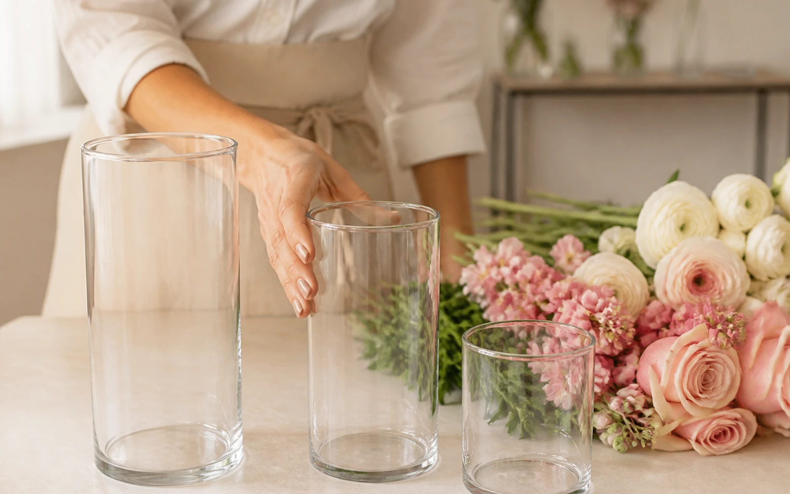 Florist choosing a clear vase for a blush and ivory stem bundle