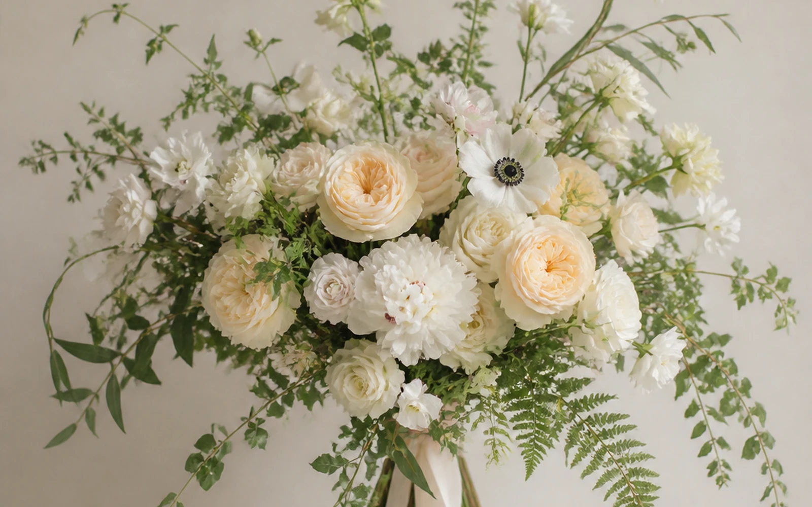 Oversized freeform wedding bouquet with broad asymmetrical reach